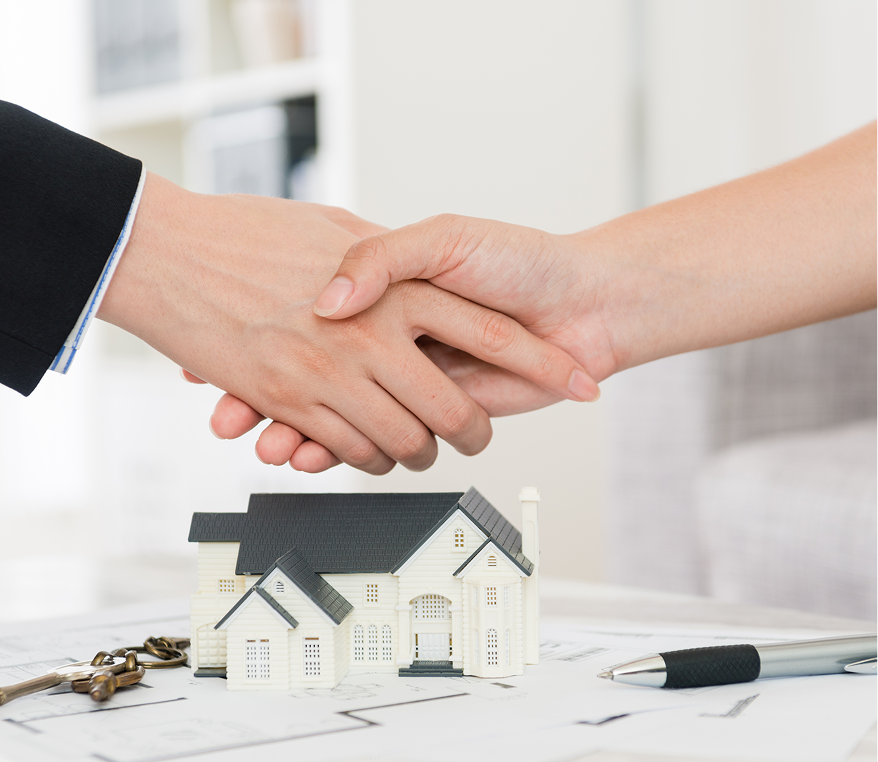 Handshake over house model and keys.