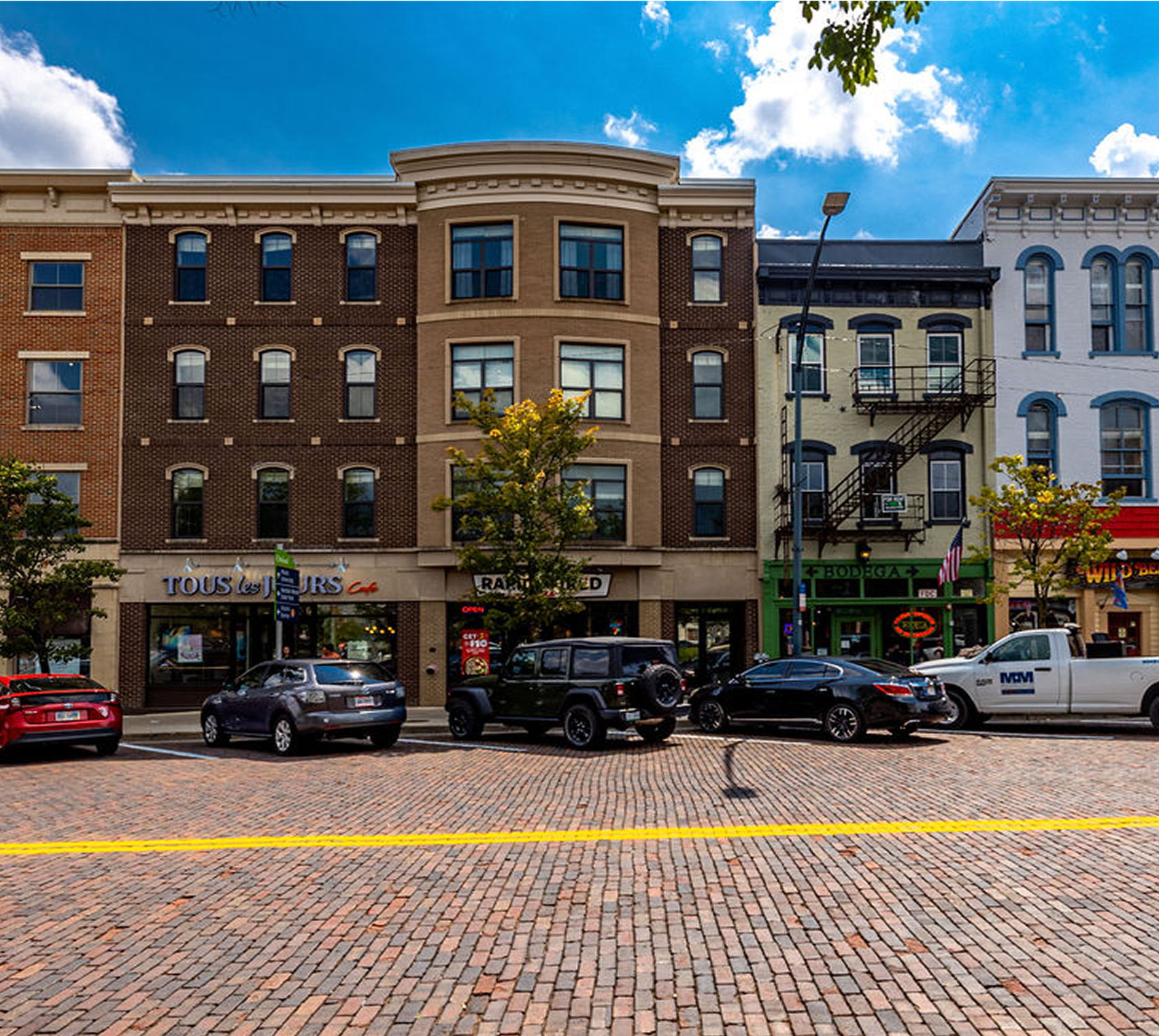 Historic brick buildings with parked cars.