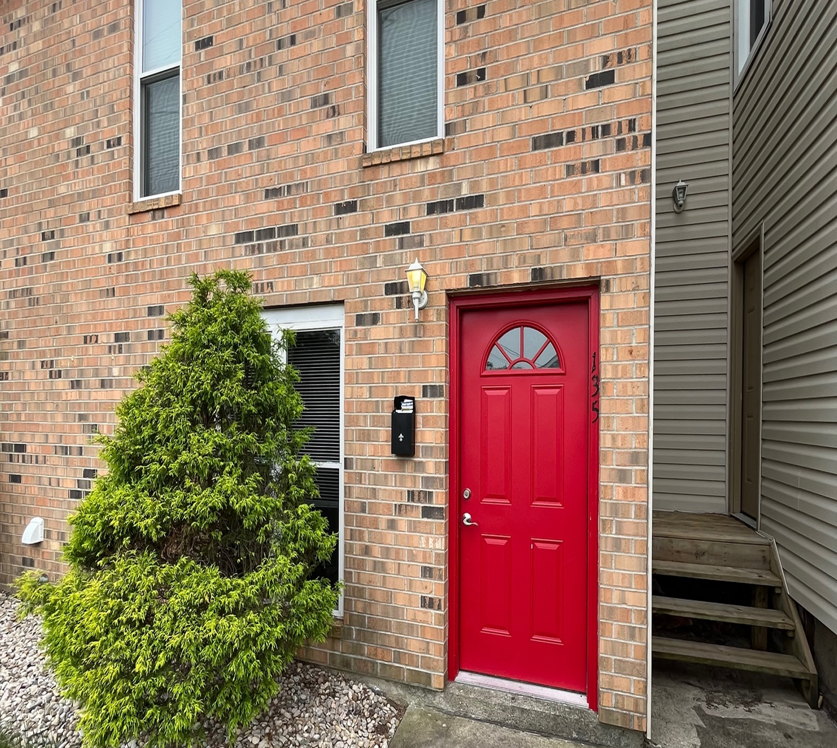 Red door on brick house exterior.