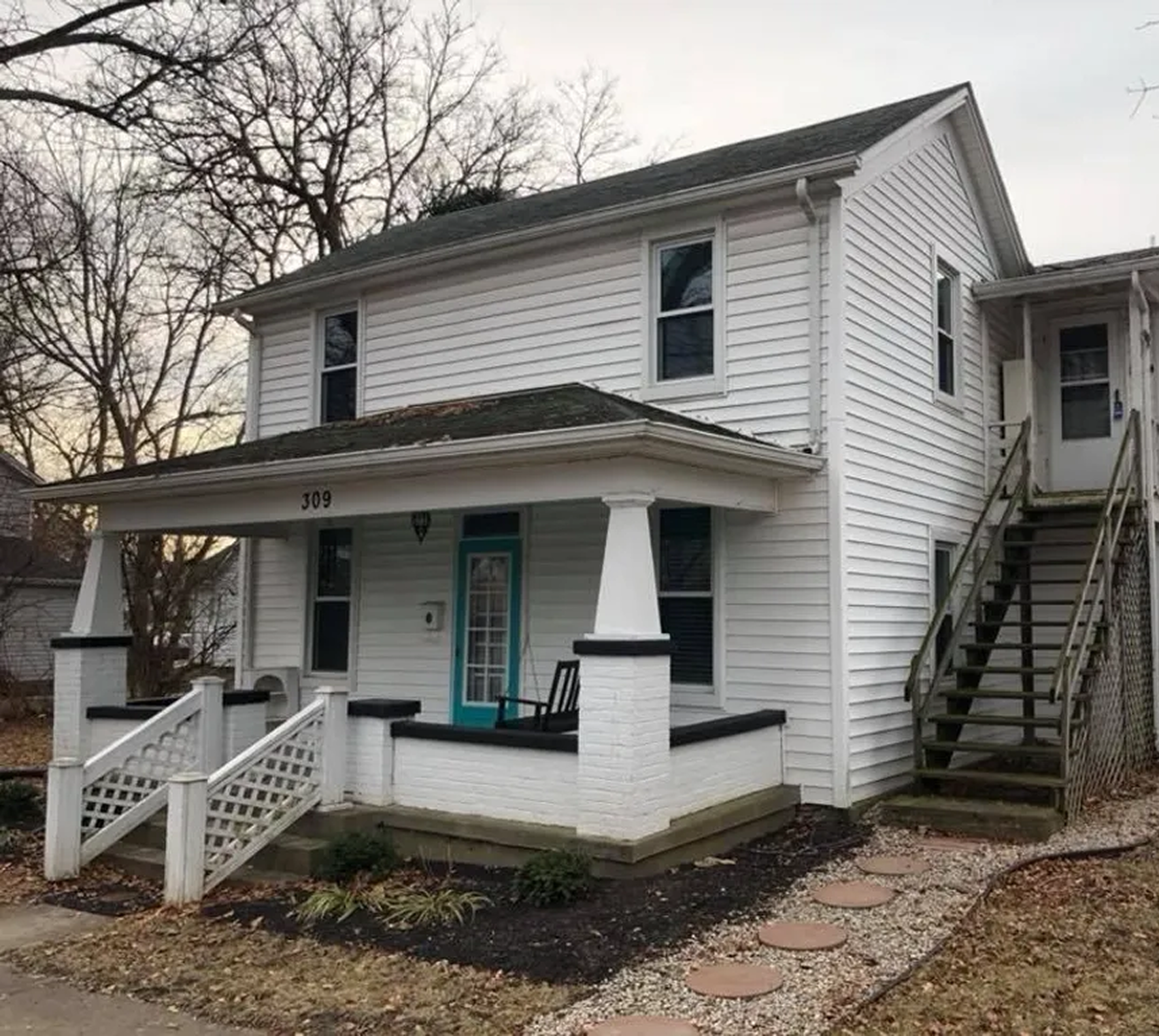 White two-story house with front porch.