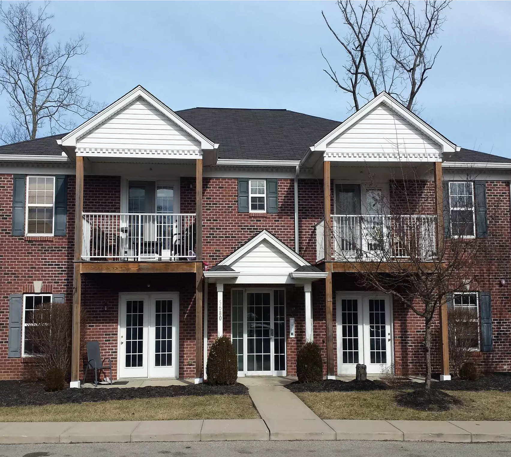 Two-story brick apartment building with balconies.