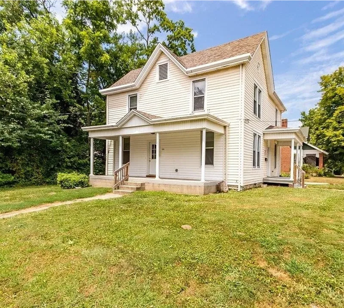 Two-story white house with green lawn.