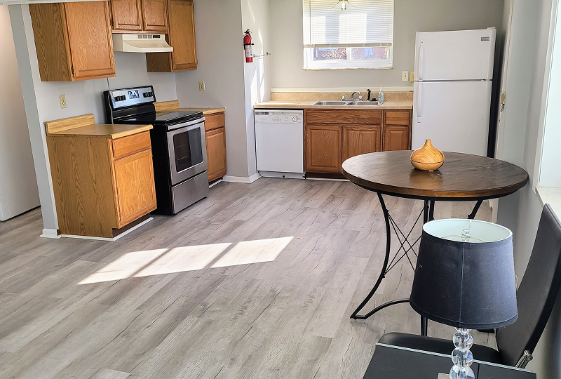 Clean kitchen with new flooring and dining table