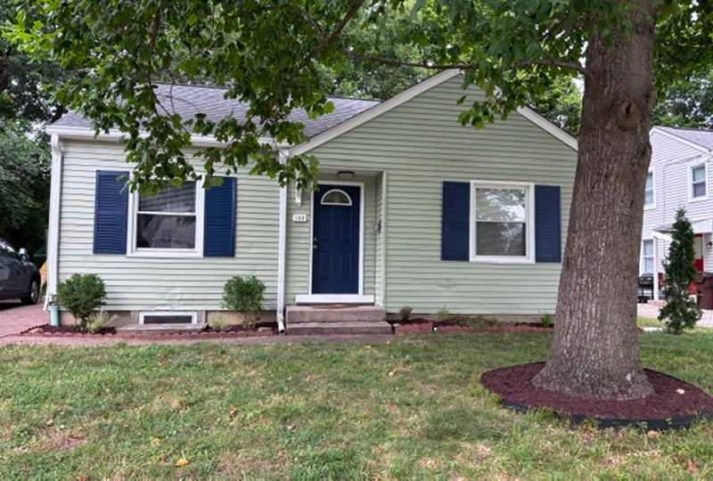 Single-story house with green siding and dark door