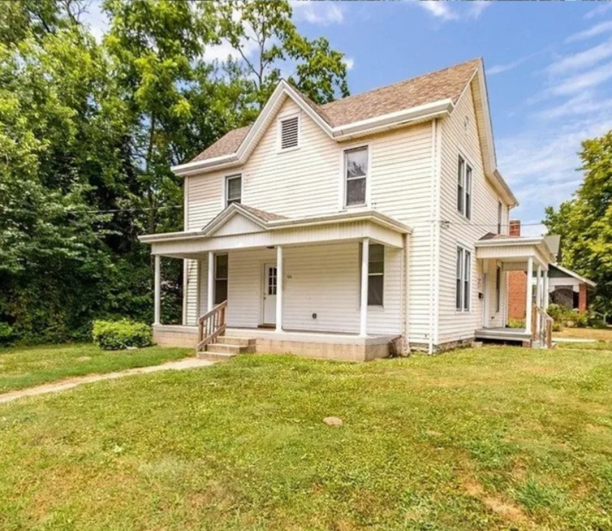 Two-story white house with front porch.