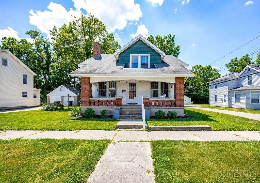Craftsman-style home with brick porch and teal siding