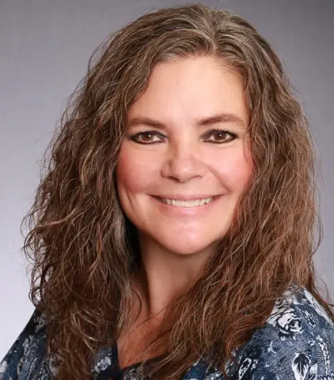 Happy woman in patterned top, grey background